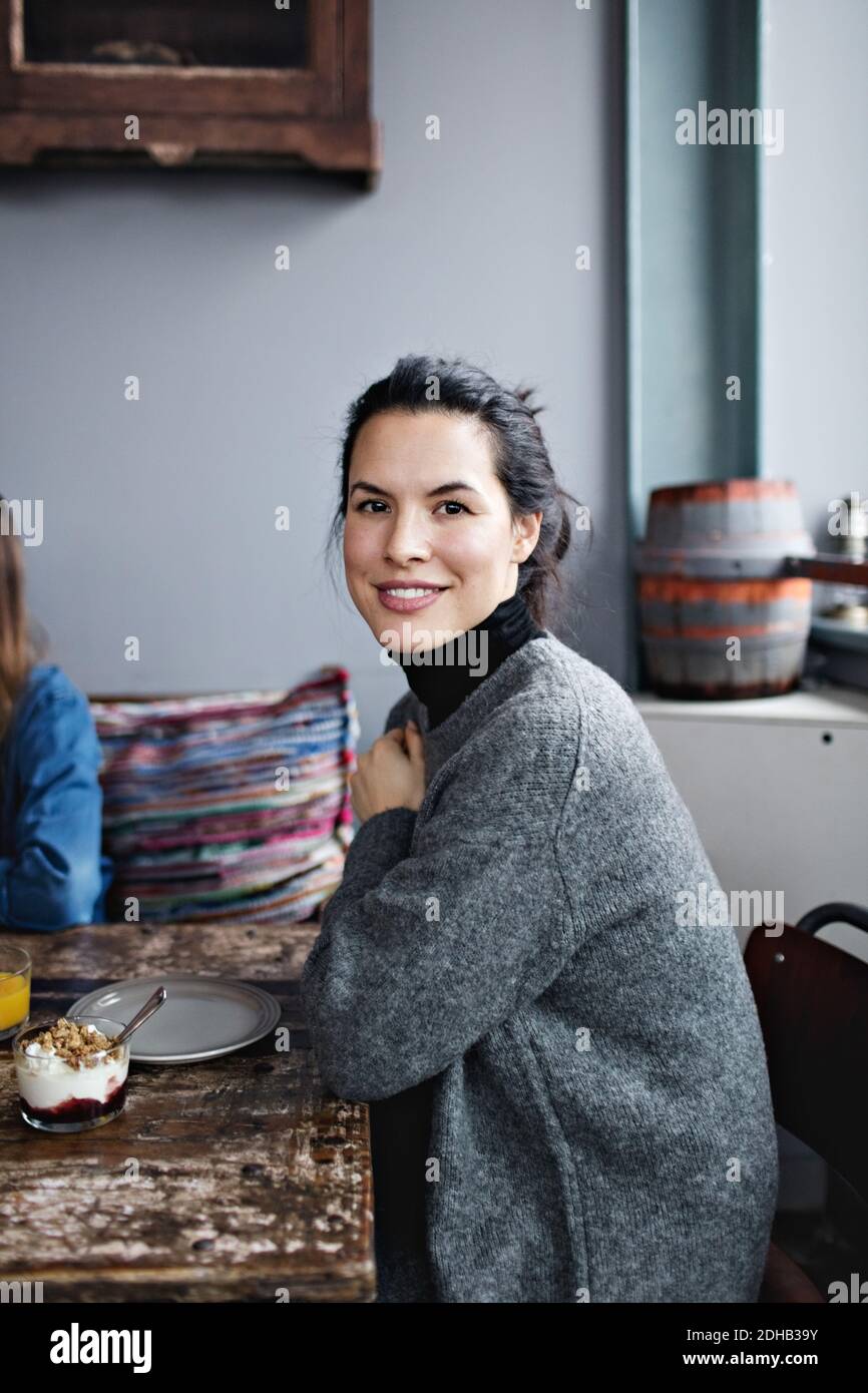 Portrait d'une femme souriante prenant un brunch à table Banque D'Images
