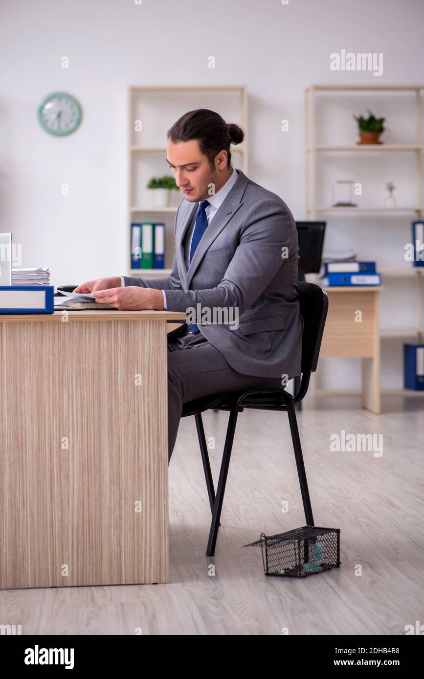 Jeune homme et mousetrap au bureau Banque D'Images