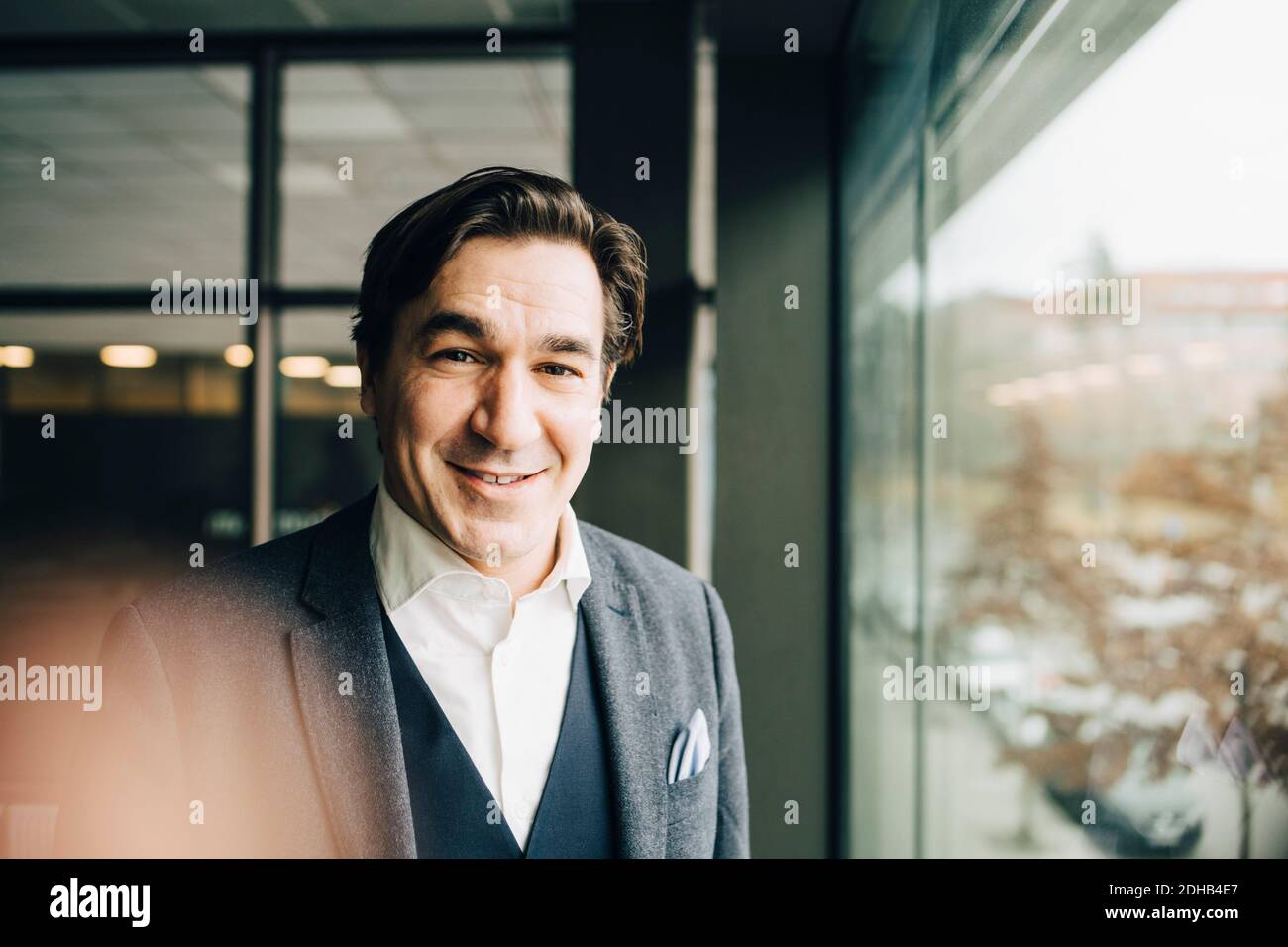 Portrait d'un homme d'affaires mi-adulte souriant et confiant au bureau Banque D'Images