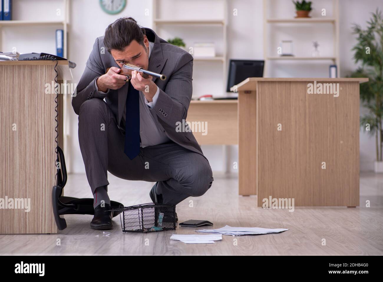 Jeune homme et mousetrap au bureau Banque D'Images