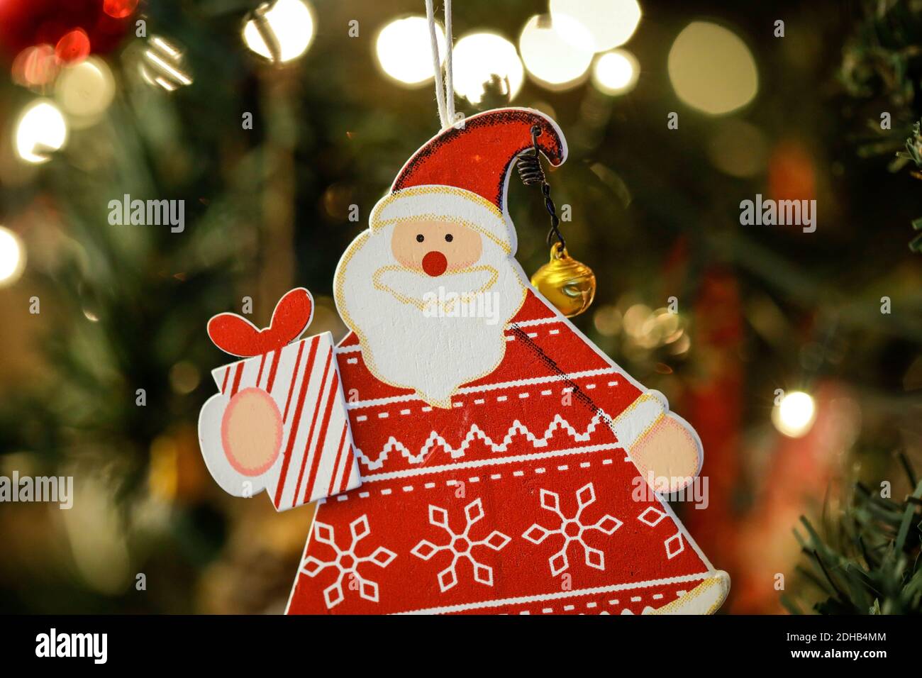 Image de faible profondeur de champ (mise au point sélective) avec un ornement en bois du Père Noël dans un arbre de Noël en plastique. Banque D'Images