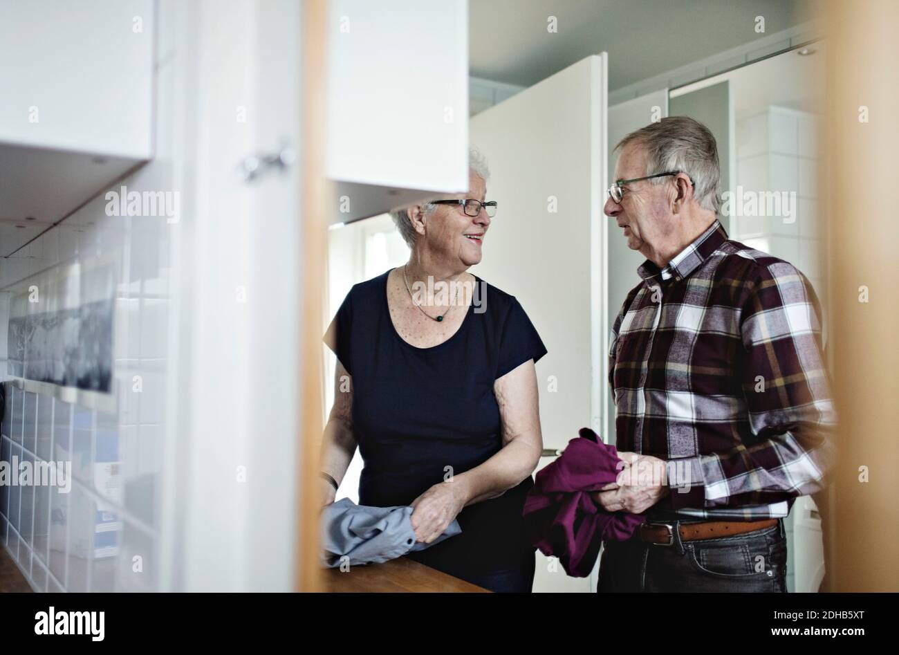 Miroir reflétant le couple senior retraité travaillant dans la salle de bains à accueil Banque D'Images