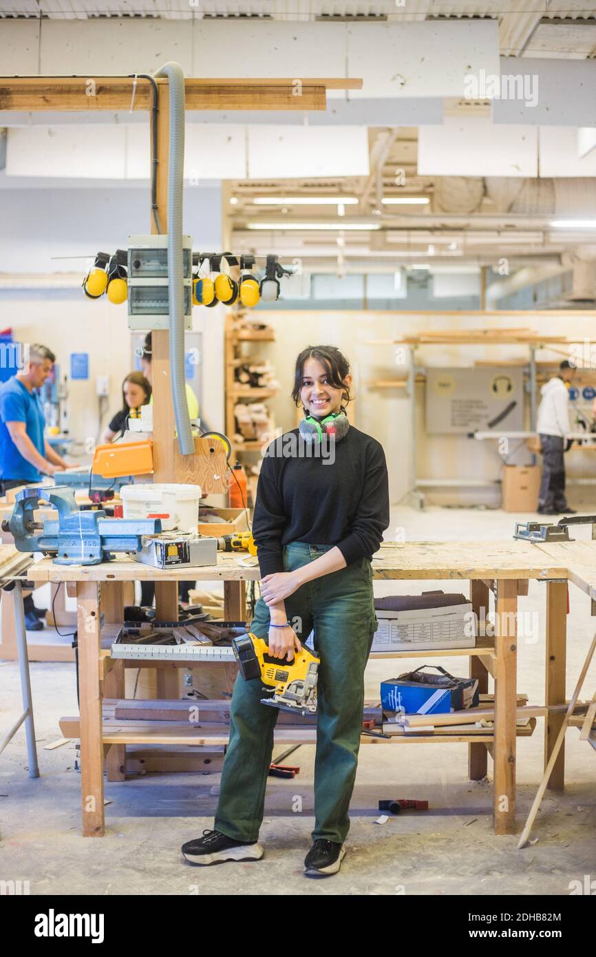 Portrait complet de jeunes femmes souriantes en pleine puissance en étant debout dans l'atelier Banque D'Images