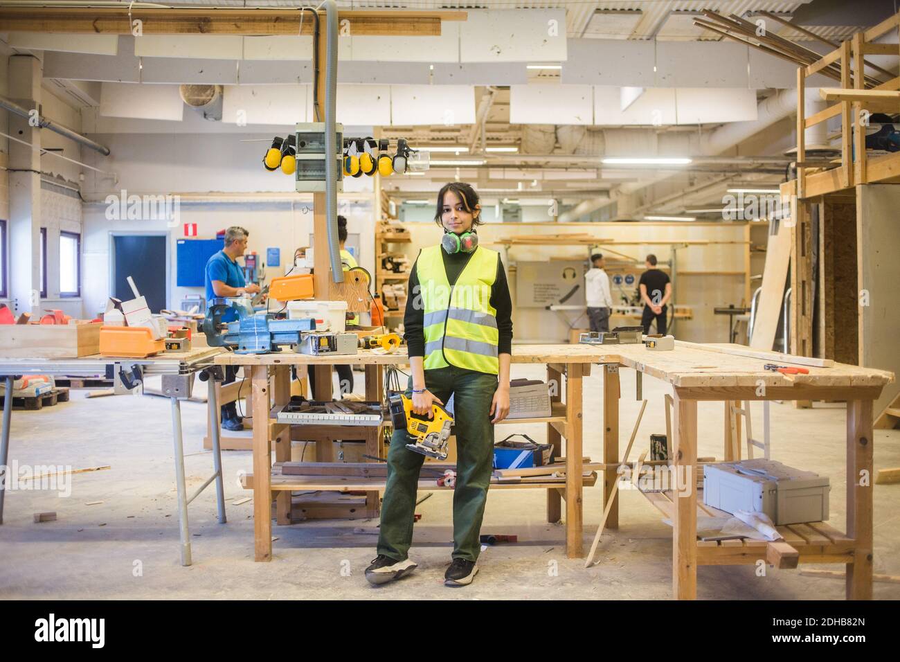 Portrait complet d'une jeune femme sûre d'elle-même, qui tient le pouvoir en étant debout dans l'atelier Banque D'Images