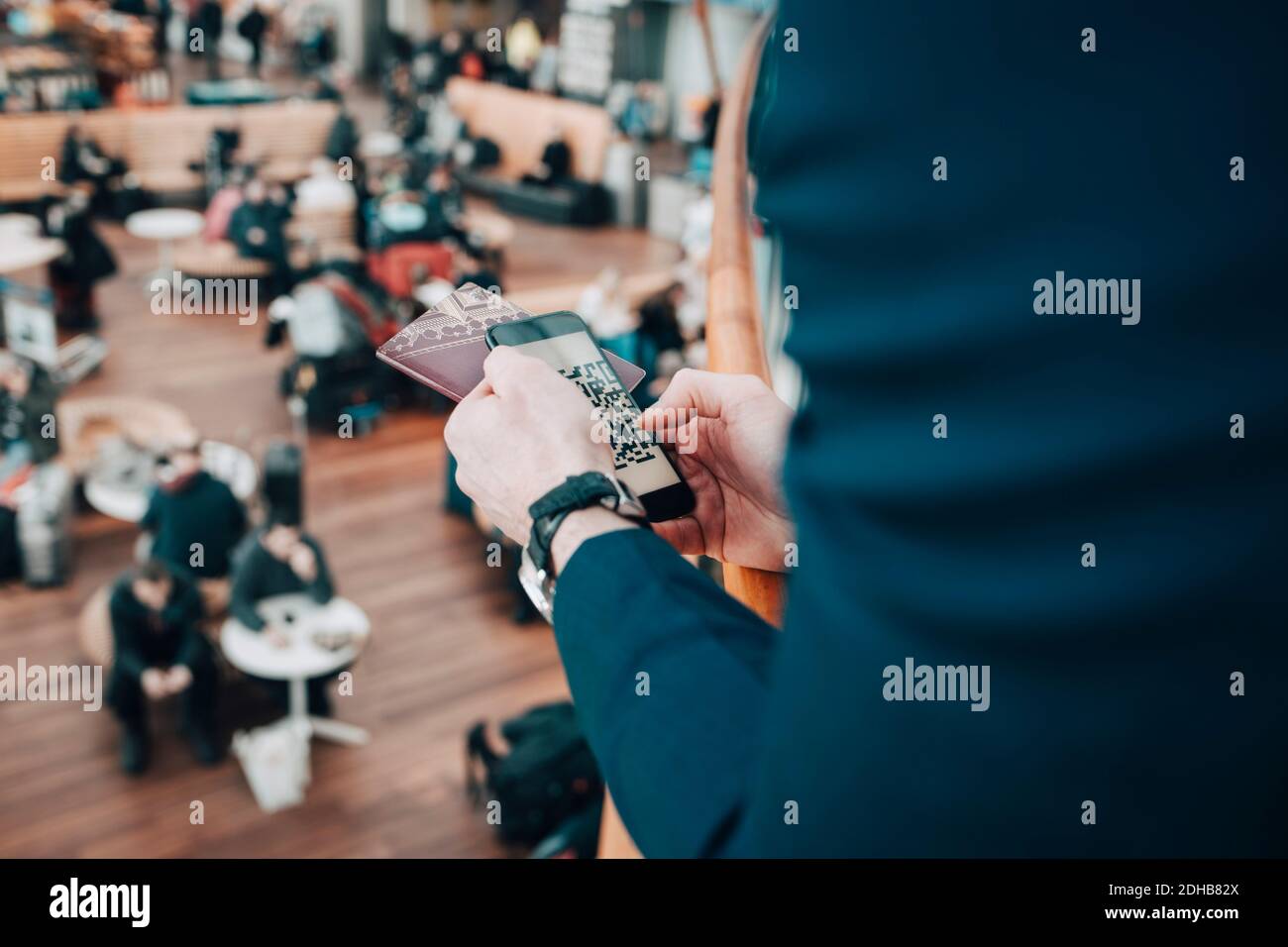 Image rognée d'un homme d'affaires tenant un téléphone portable et un passeport aéroport Banque D'Images