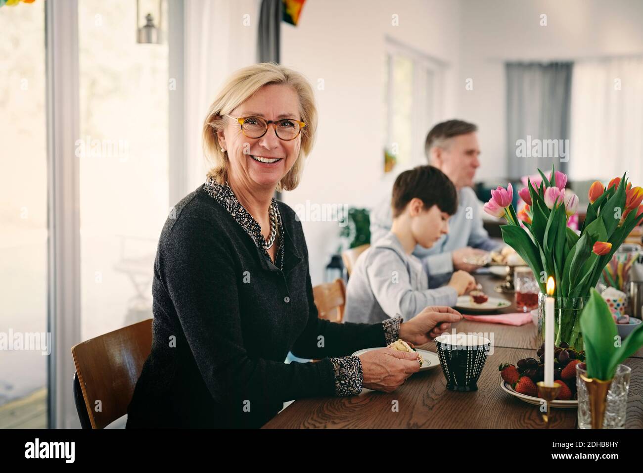 Portrait de grand-mère souriante assis avec la famille à table pendant fête Banque D'Images