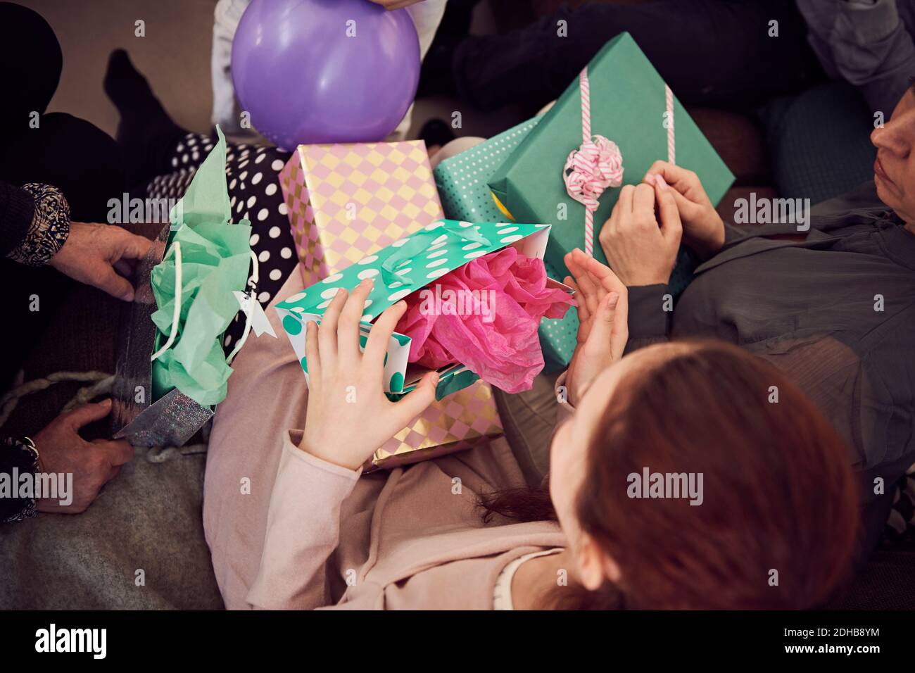Vue en grand angle de la fille recevant des cadeaux d'anniversaire de la famille à la maison Banque D'Images
