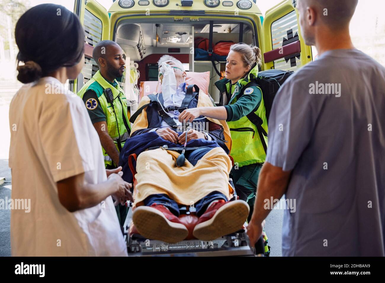 Les professionnels de la santé qui s'intéressent aux ambulanciers paramédicaux avec le patient contre l'ambulance Banque D'Images