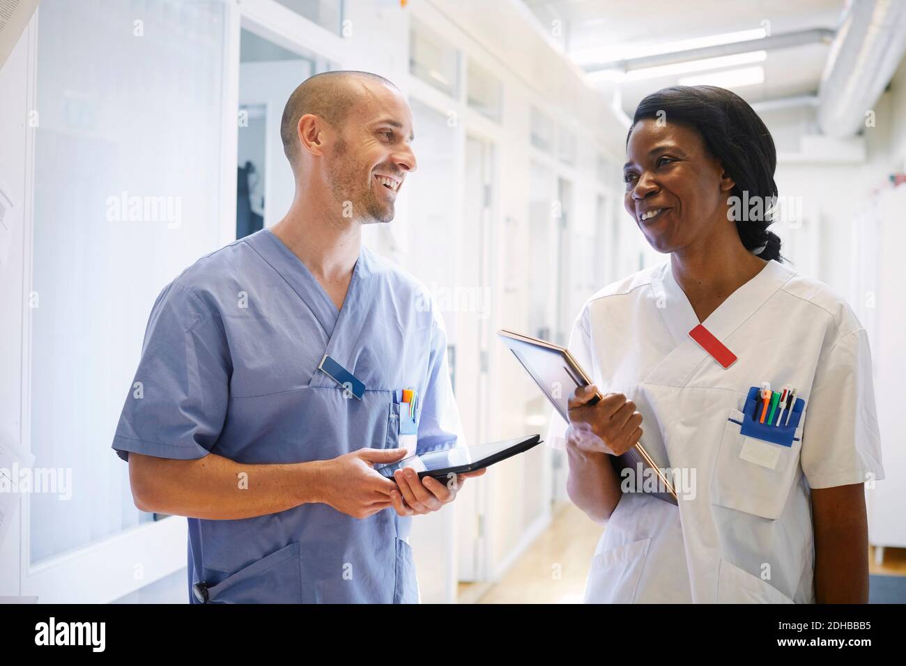 Des professionnels de la santé heureux en uniforme discutant dans le couloir de l'hôpital Banque D'Images