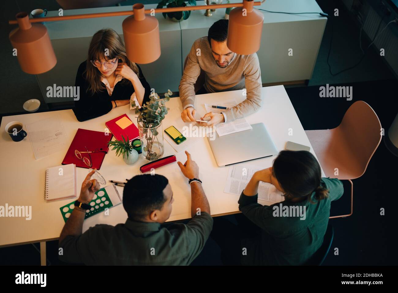 Vue d'ensemble de l'équipe d'affaires multiethnique discutant en étant assis au bureau dans le bureau créatif Banque D'Images