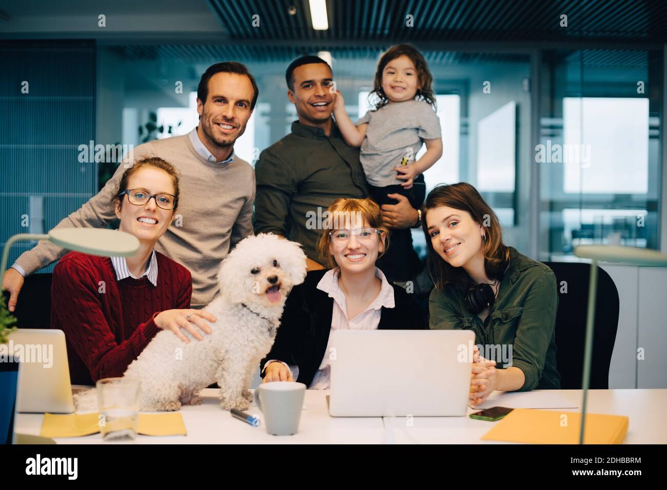 Portrait d'une équipe d'affaires souriante avec un enfant et un chien à bureau créatif Banque D'Images