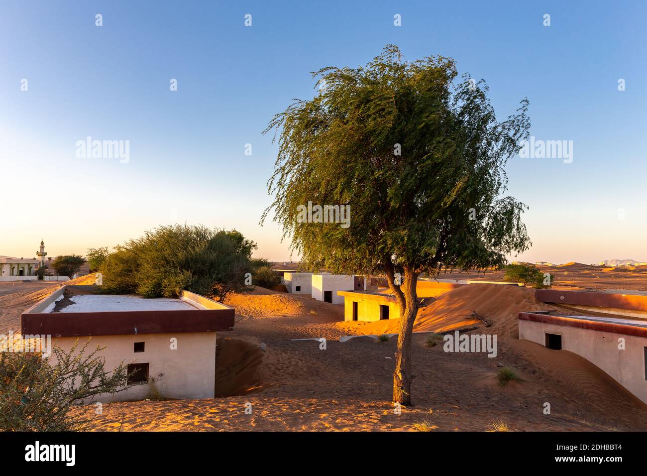 Paysage de ville fantôme d'Al Madame, village enterré dans des dunes de sable, chassé par le mal djinn, dans le désert de Sharjah, Émirats arabes Unis, coucher de soleil. Banque D'Images