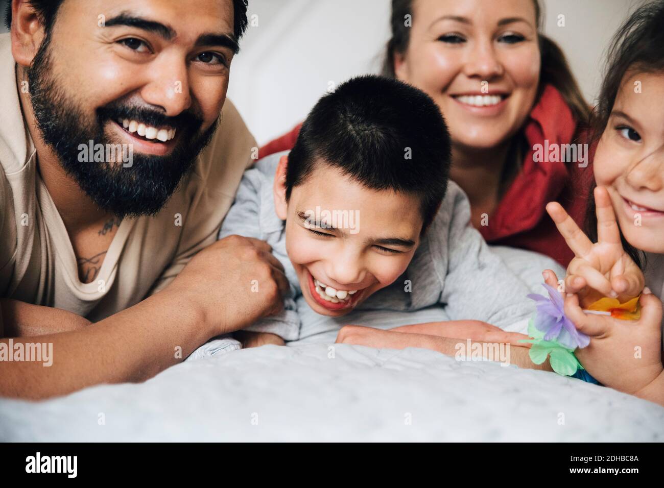 Parents heureux avec des enfants allongé sur le lit à la maison Banque D'Images
