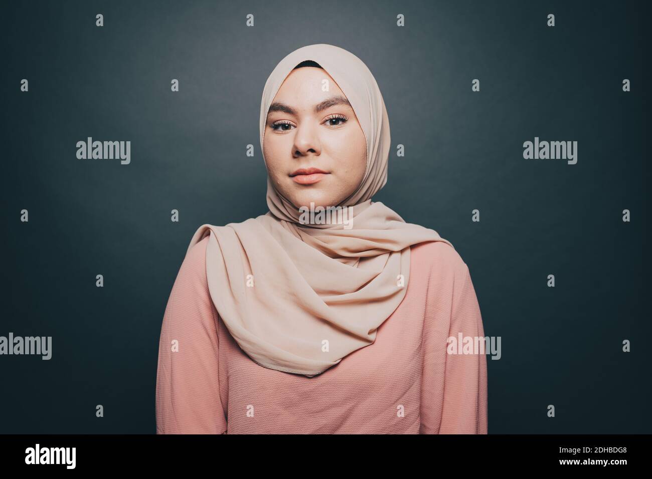 Portrait d'une jeune femme confiante portant le hijab sur fond gris Banque D'Images