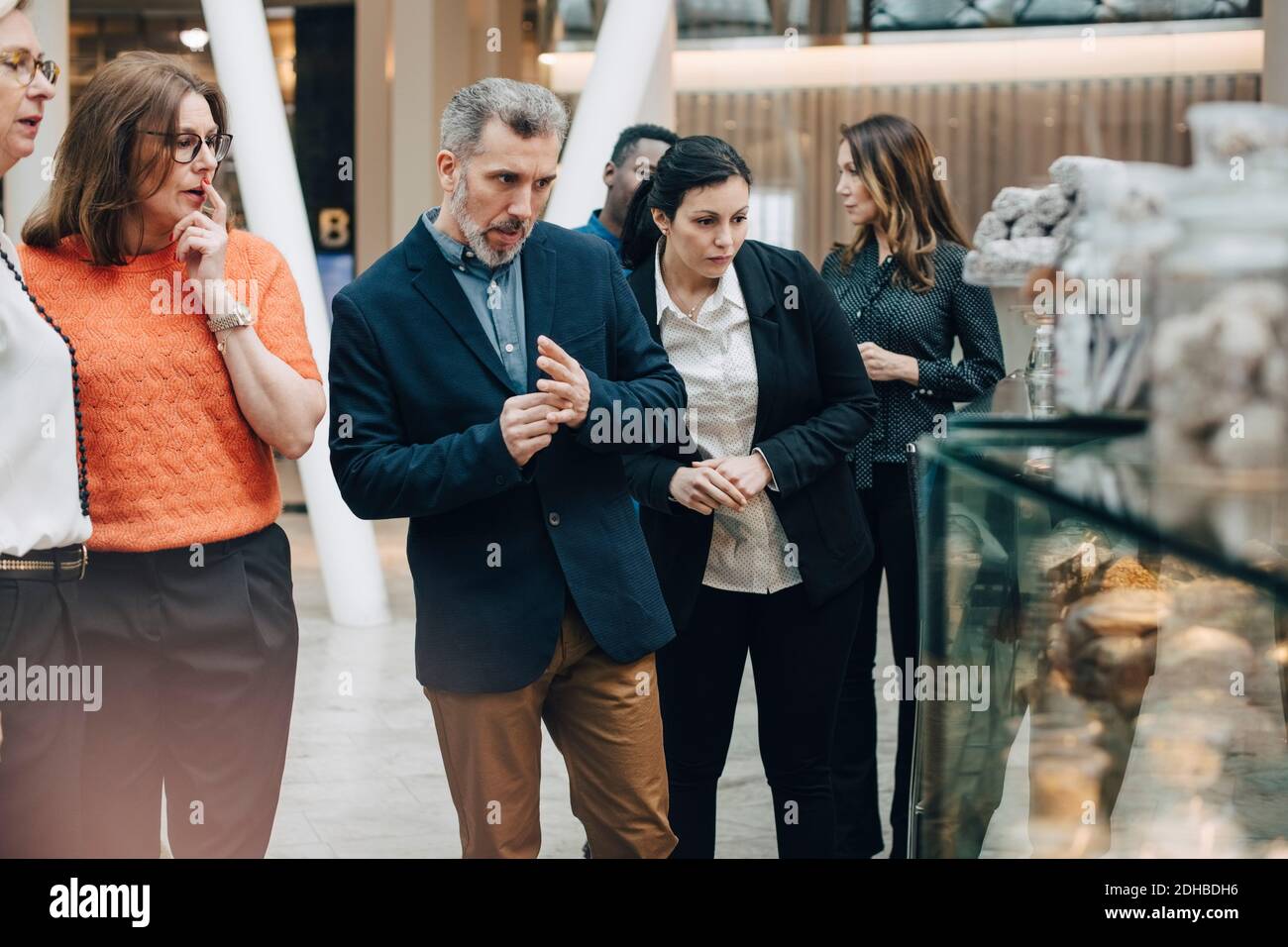Les gens d'affaires regardent des pains dans la fenêtre d'affichage lors de la conférence Banque D'Images