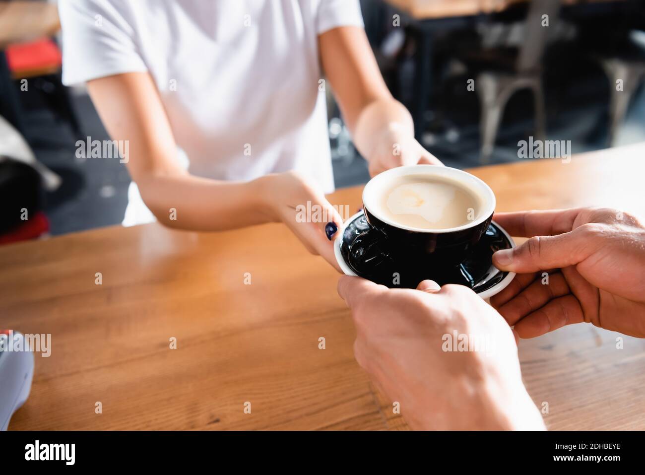 vue rognée de l'homme prenant une tasse de café du barista sur un arrière-plan flou Banque D'Images