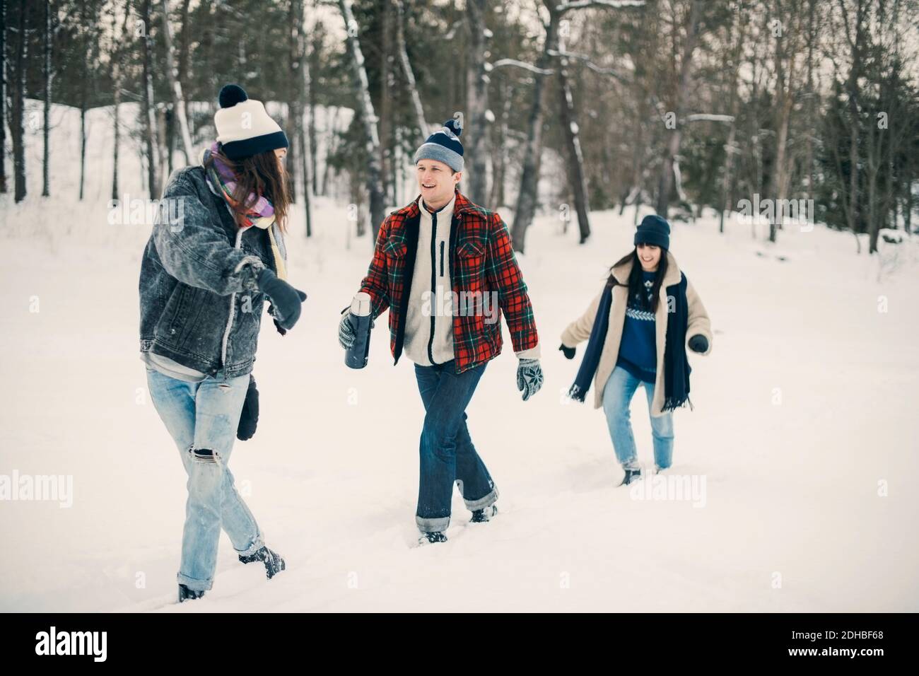 Il y a plein d'amis qui parlent tout en marchant sur de la neige champ Banque D'Images