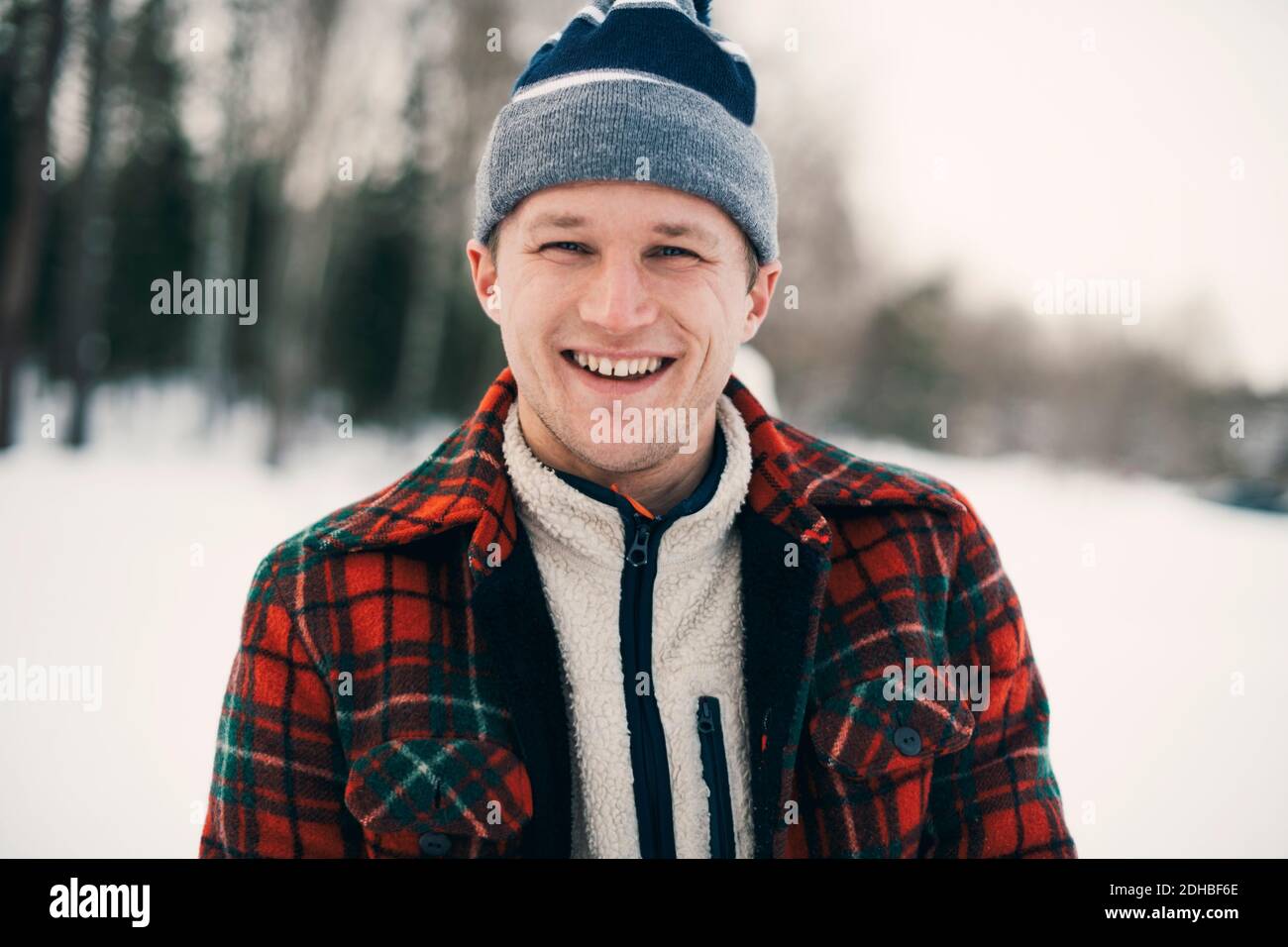 Portrait de l'homme heureux dans des vêtements chauds au parc pendant hiver Banque D'Images