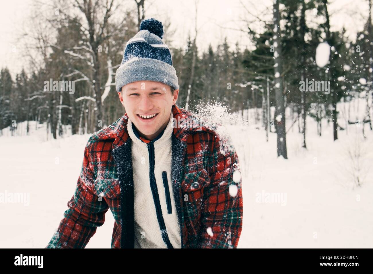 Portrait d'un homme mi-adulte heureux en vêtement chaud champ recouvert de neige Banque D'Images