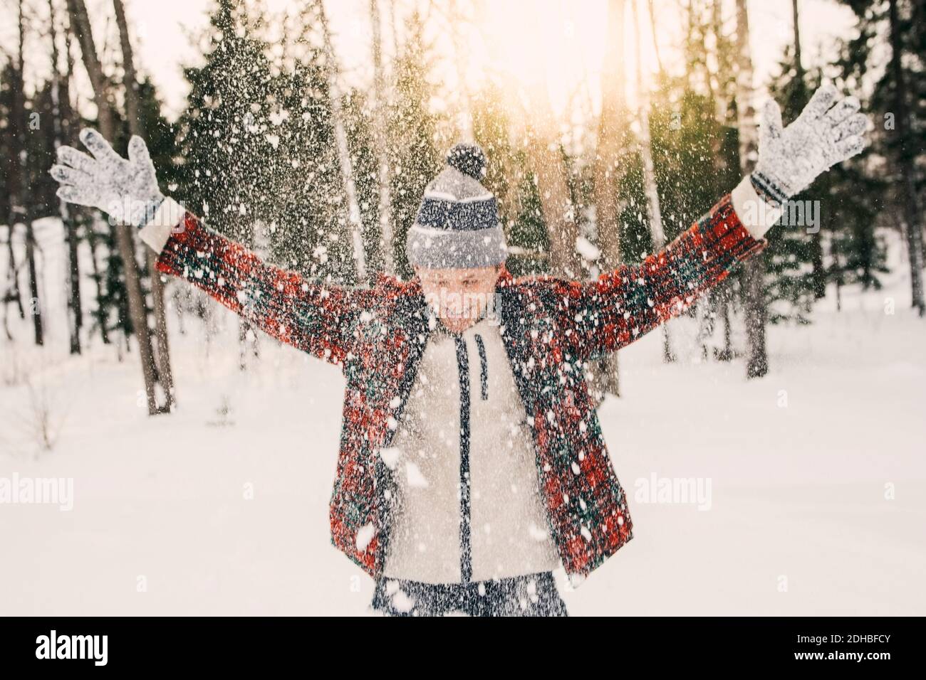 Joyeux homme moyen adulte jouant avec la neige sur la neige couverte champ Banque D'Images