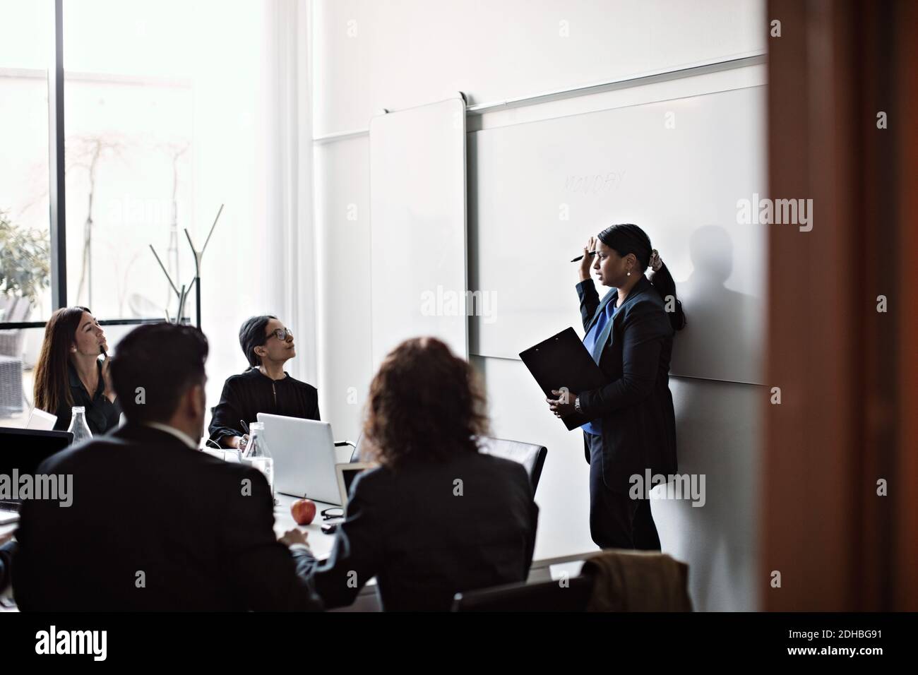 Femme d'affaires qui donne une présentation à ses collègues lors d'une réunion de bureau Banque D'Images