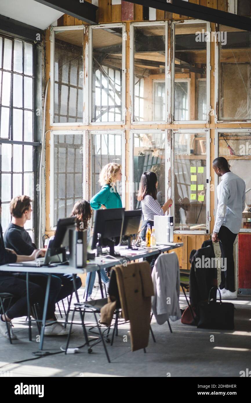 Équipe de jeunes programmeurs d'ordinateur discutant de nouvelles stratégies d'affaires à espace de travail créatif Banque D'Images