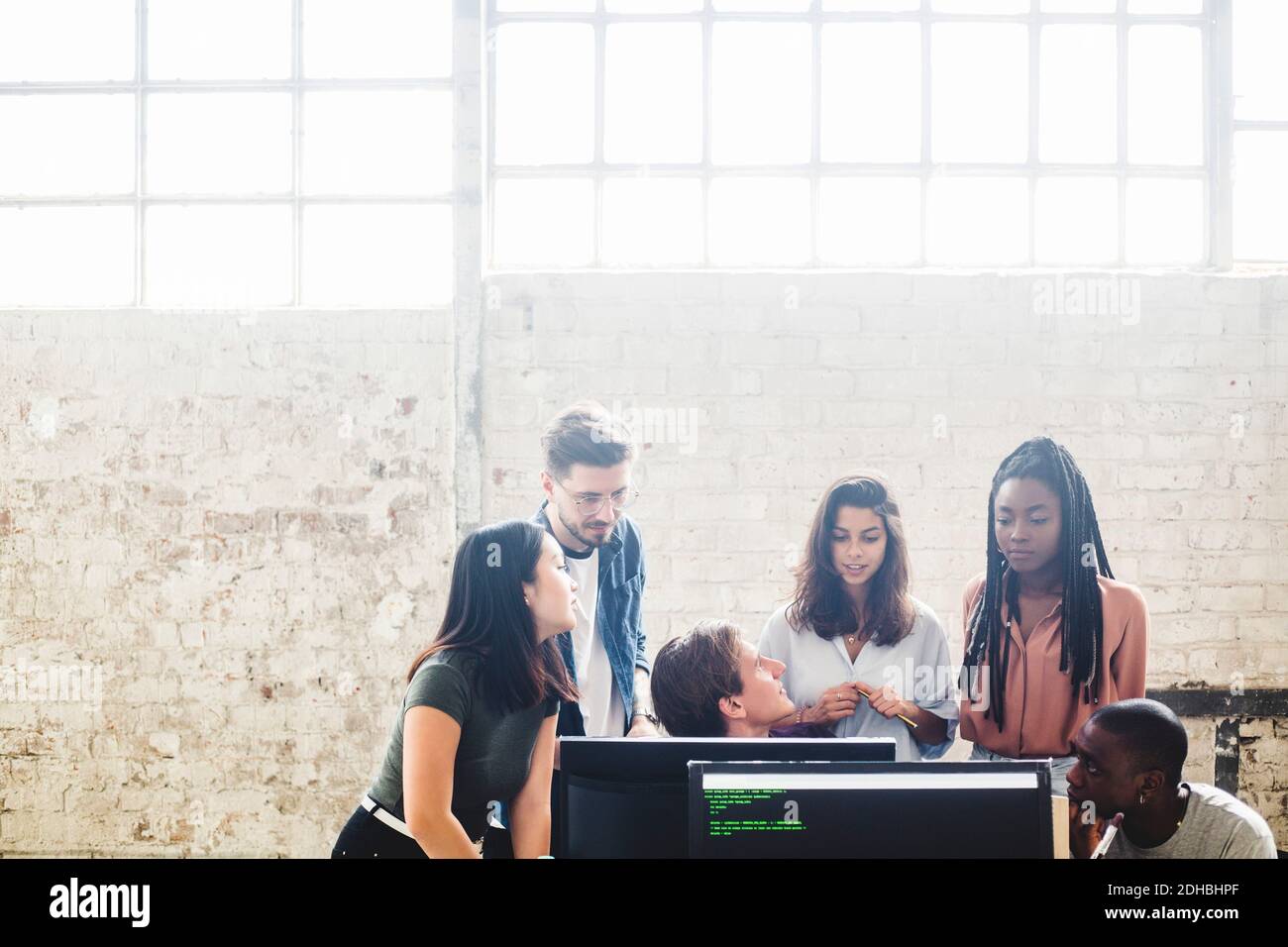 Programmeurs professionnels travaillant en équipe tout en codant sur un lieu de travail créatif Banque D'Images