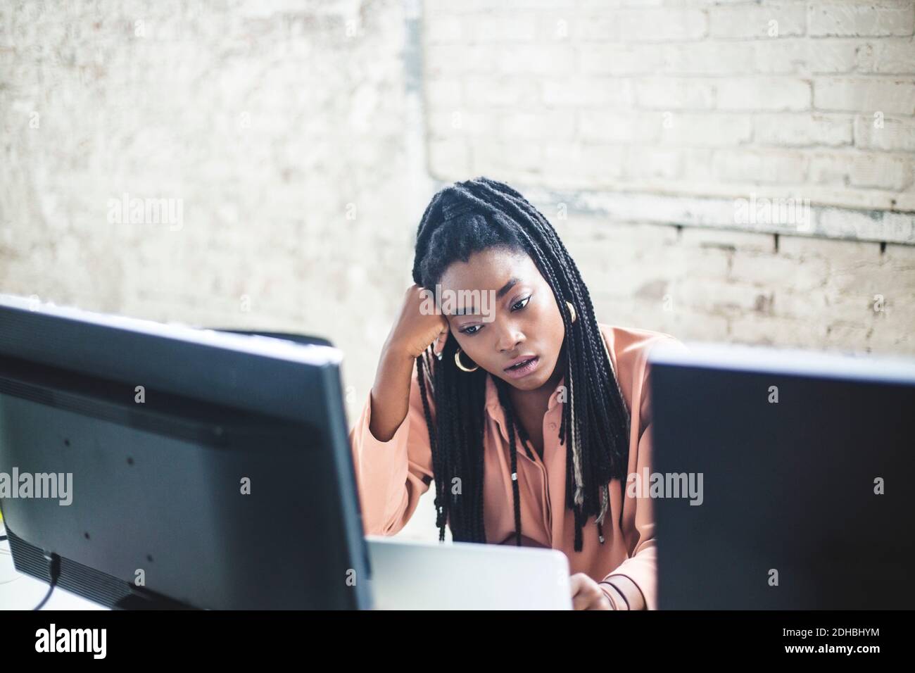 Vue en grand angle des jeunes femmes hacker informatique encodant à bureau Banque D'Images