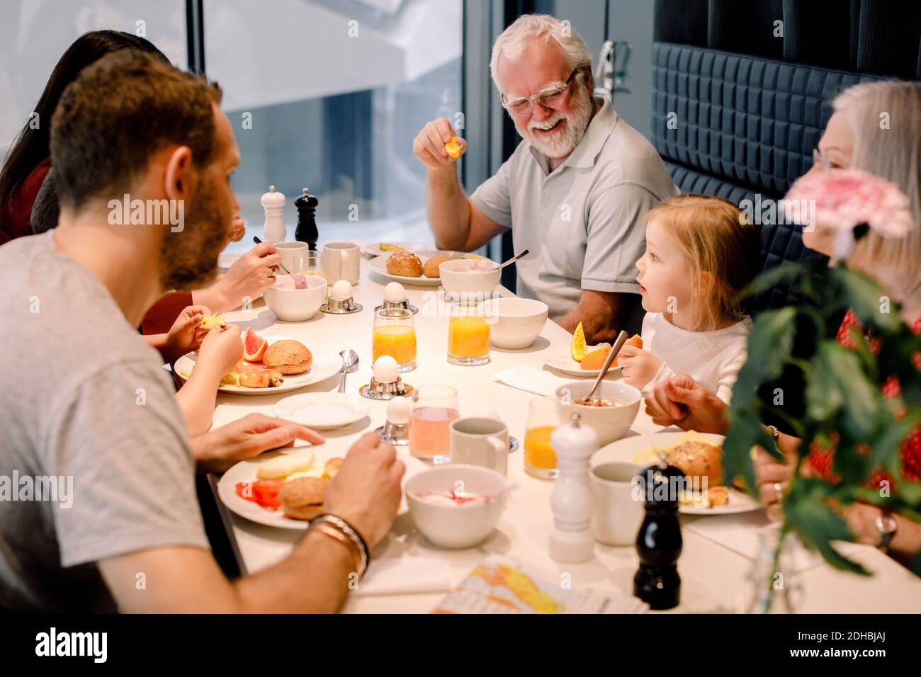 Vue en grand angle de la famille de plusieurs générations ayant des aliments à table dans le restaurant Banque D'Images