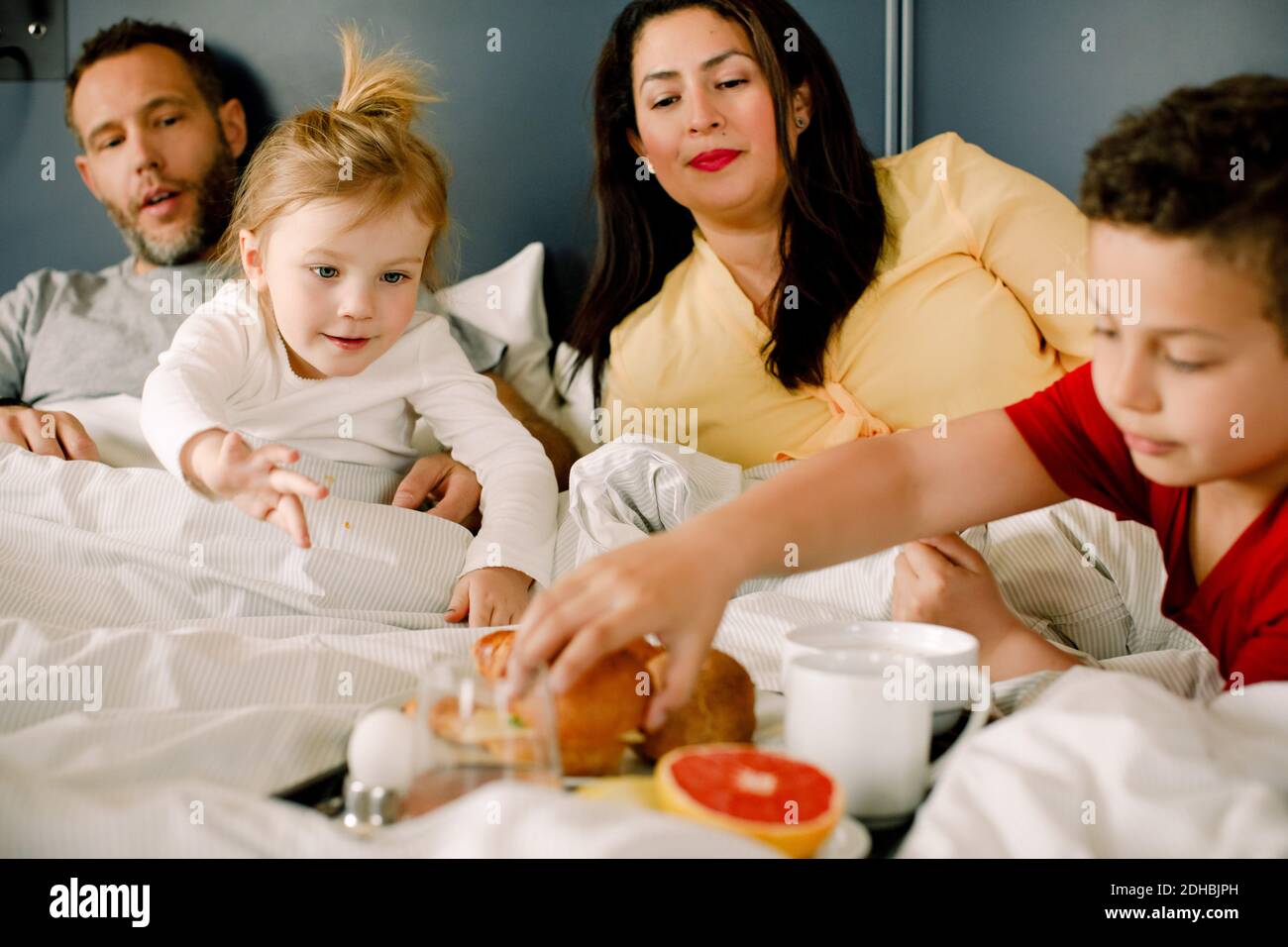 Family having breakfast in bed Banque D'Images