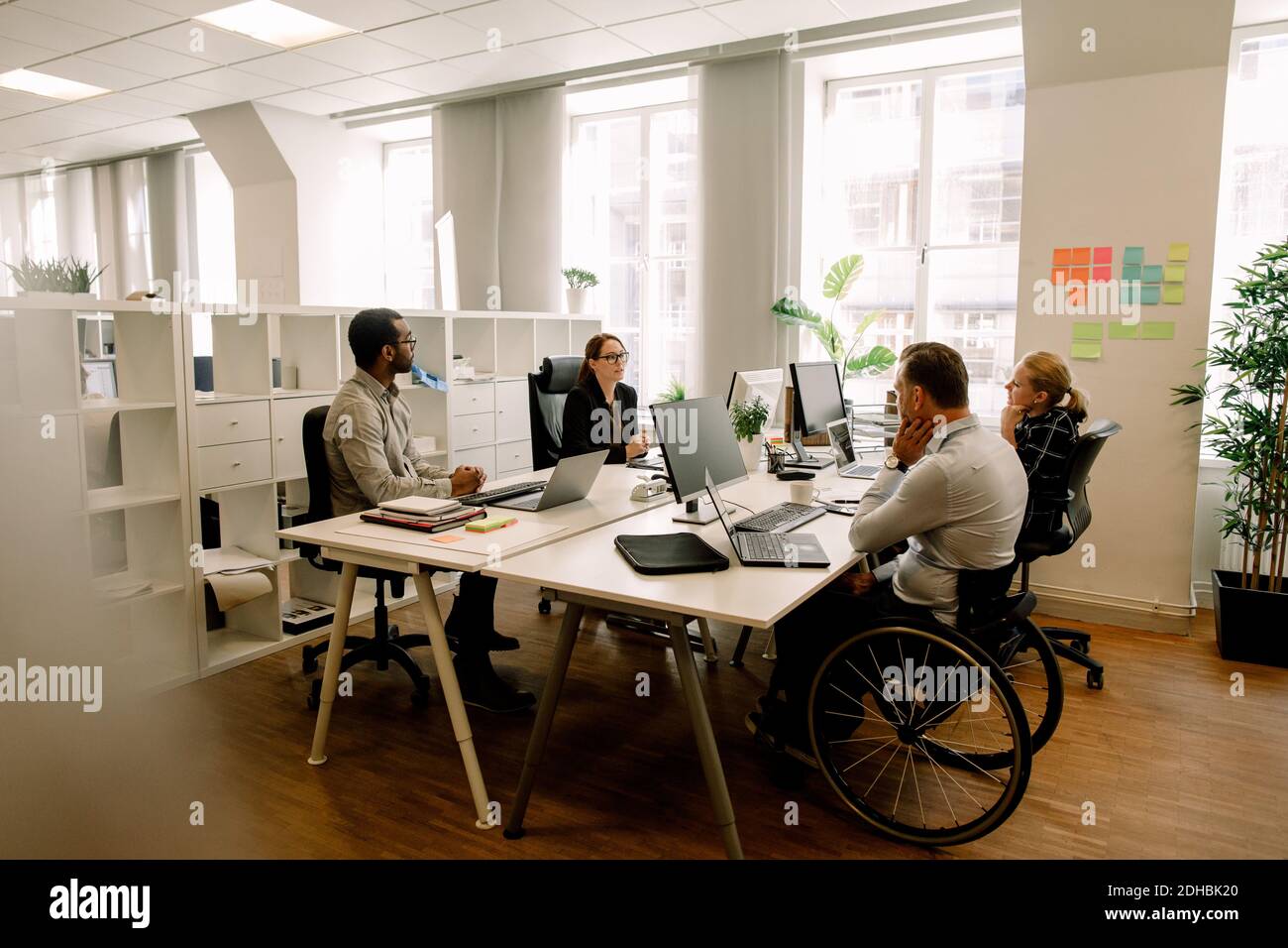 Collègues d'affaires avec un responsable des ventes handicapé travaillant au bureau à bureau Banque D'Images