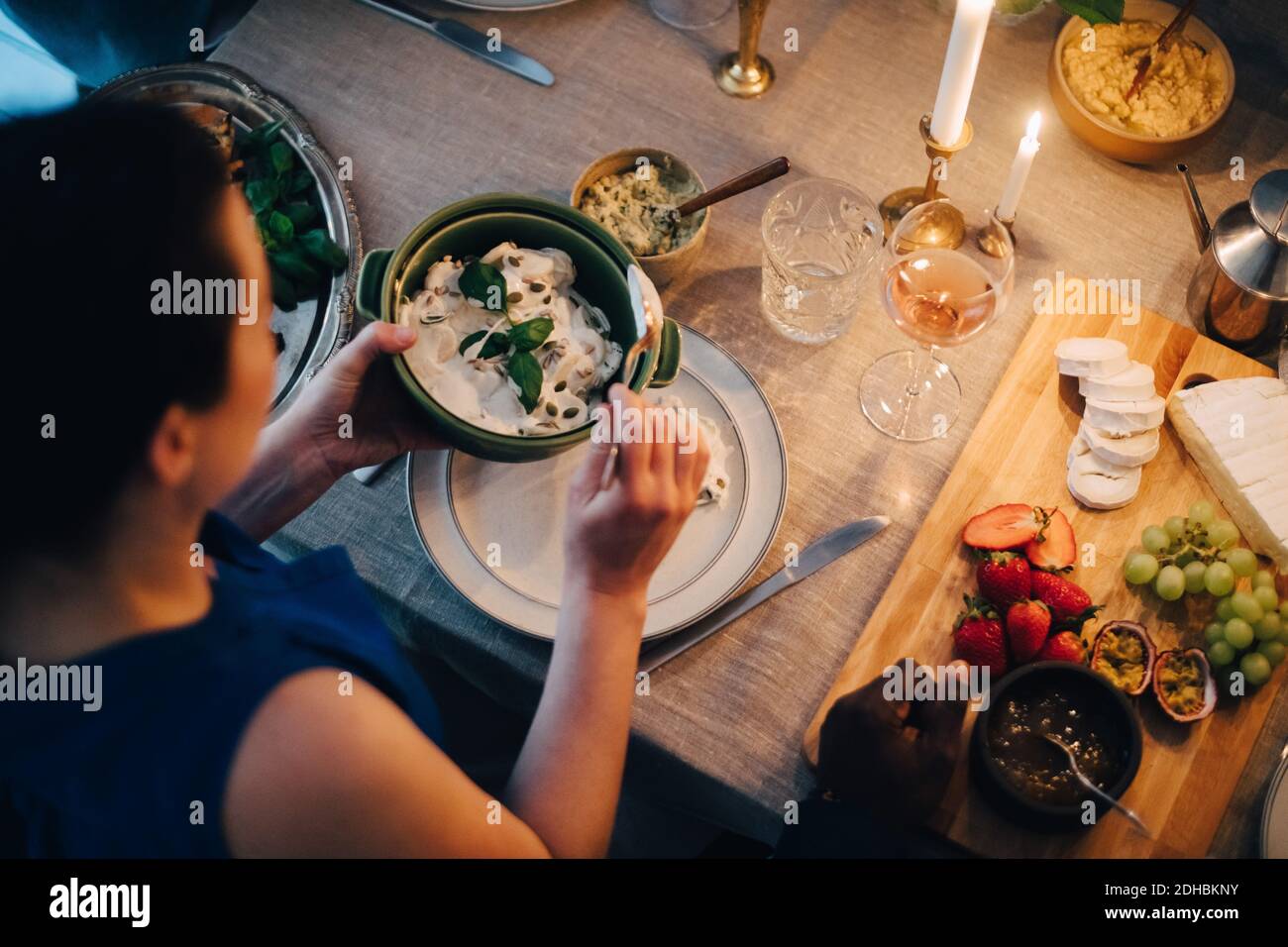 Vue en grand angle de la femme qui mange à la table à manger pour le dîner Banque D'Images