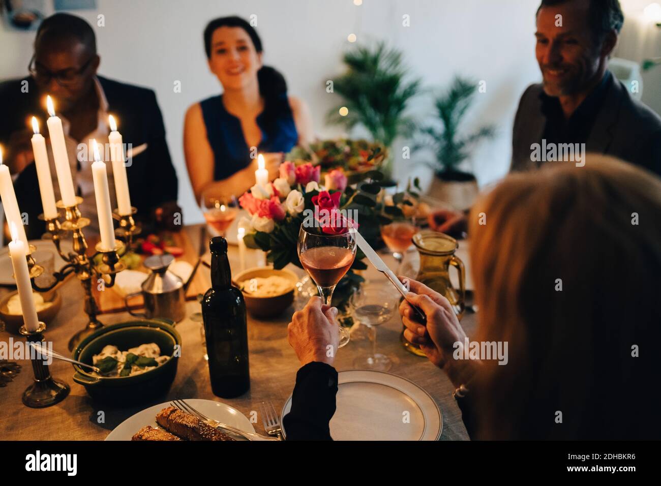 Une femme qui a pris un toast avec des verres de vin lors d'un dîner à la maison Banque D'Images