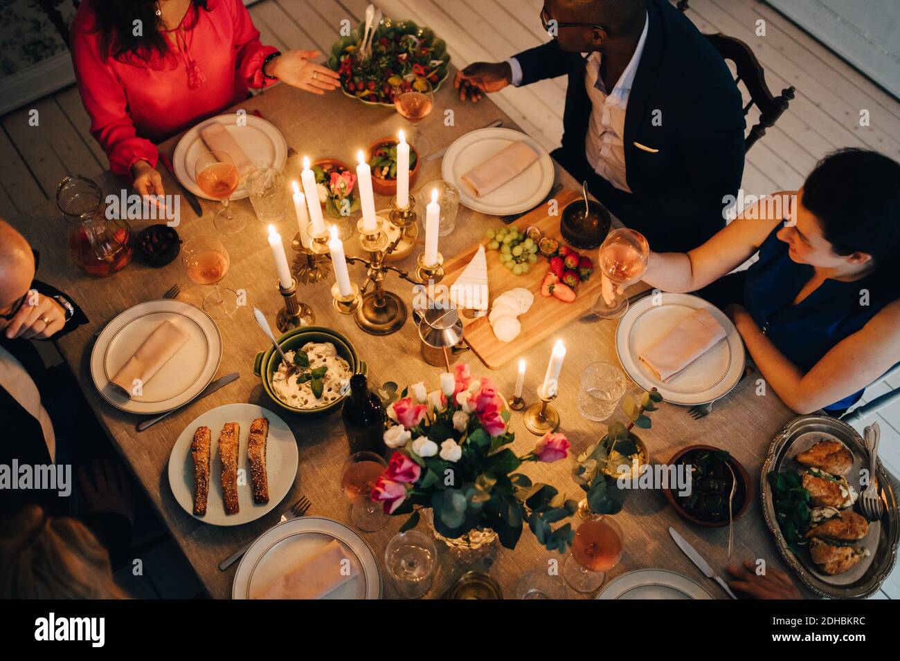 Vue en grand angle des amis qui dînaient à la table en fête Banque D'Images