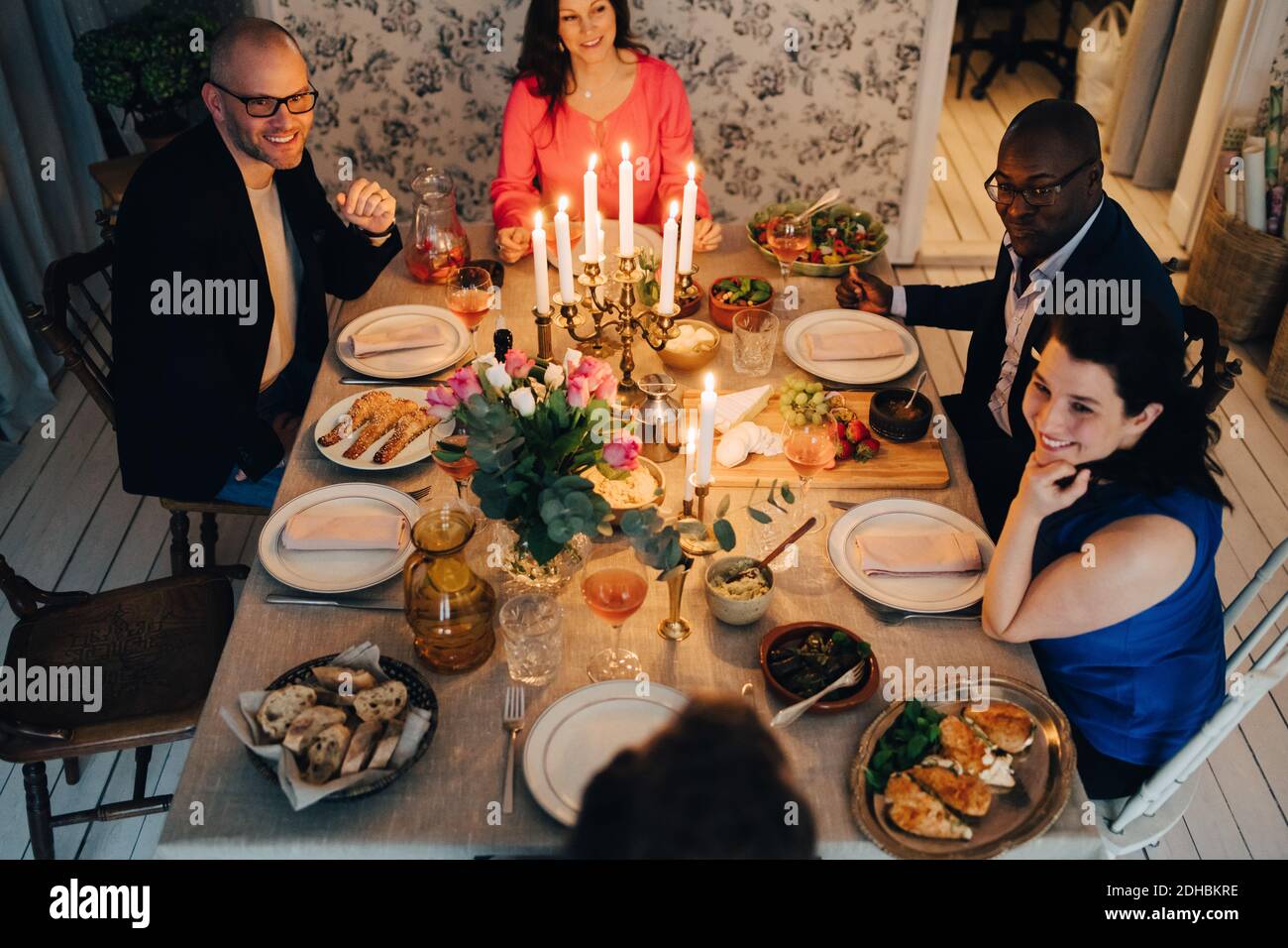 Des amis hommes et femmes matures dînant à la fête Banque D'Images
