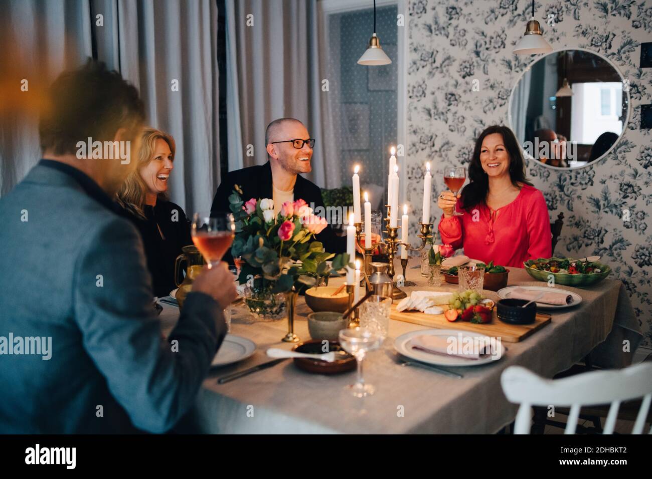 Des amis adultes, hommes et femmes, apprécient le dîner à la maison Banque D'Images