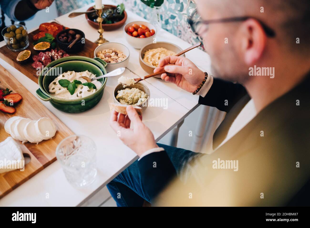 Vue en grand angle de l'homme ayant de la nourriture à la table pendant dîner Banque D'Images