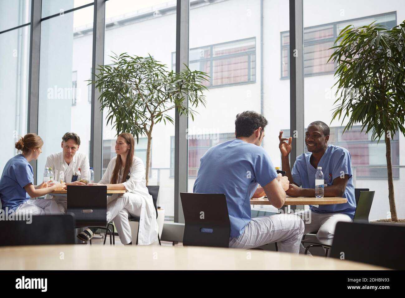 Équipe médicale multiethnique assise à la cafétéria de l'hôpital Banque D'Images