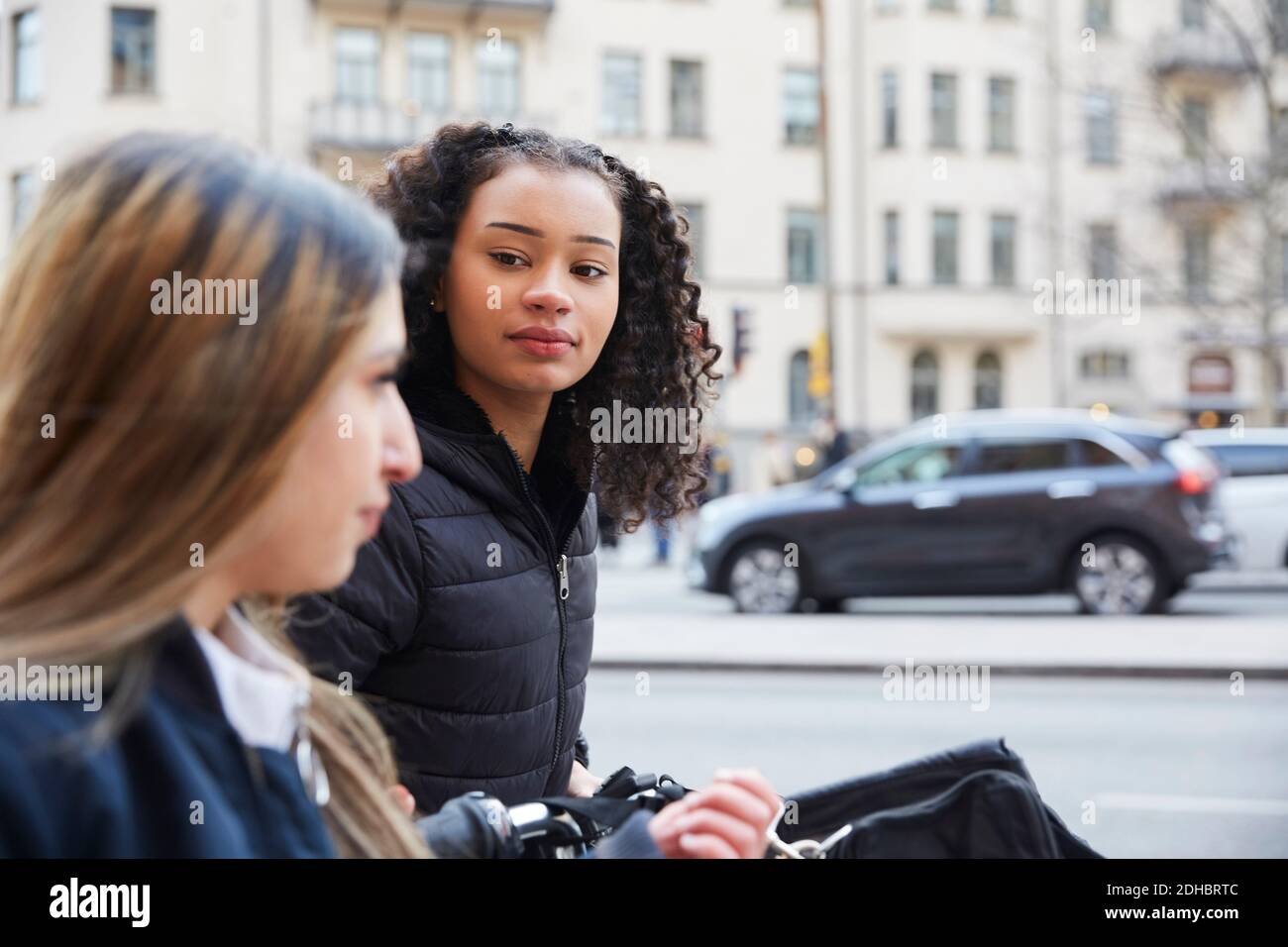 Une adolescente regarde une amie dans la rue de la ville Banque D'Images