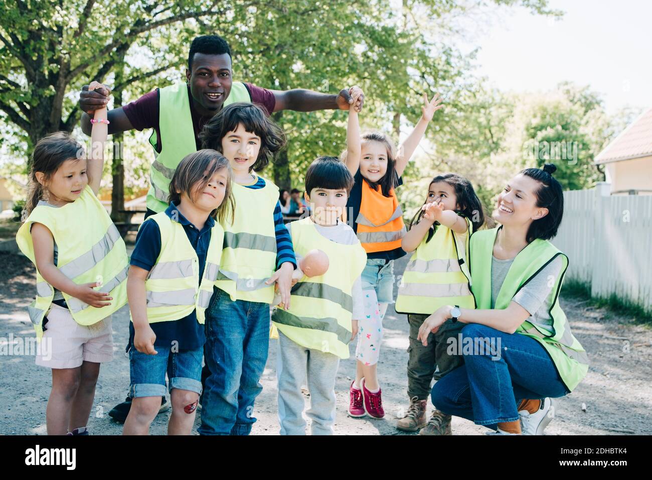 Les élèves et les enseignants d'âge préscolaire multiethnique profitent de l'aire de jeux Banque D'Images