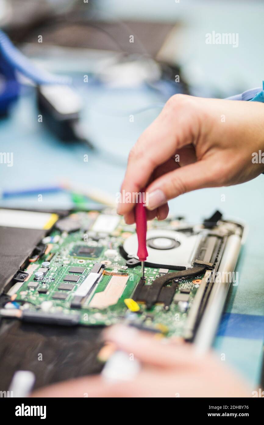 Main rognée du technicien réparant la partie de l'ordinateur sur la table Banque D'Images