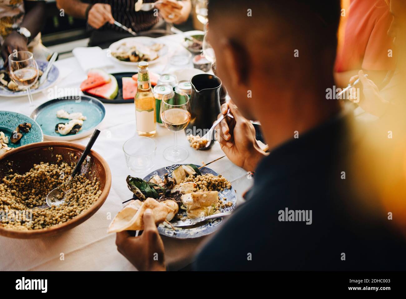 Vue en grand angle sur le dîner de l'homme à la table à manger en fête Banque D'Images