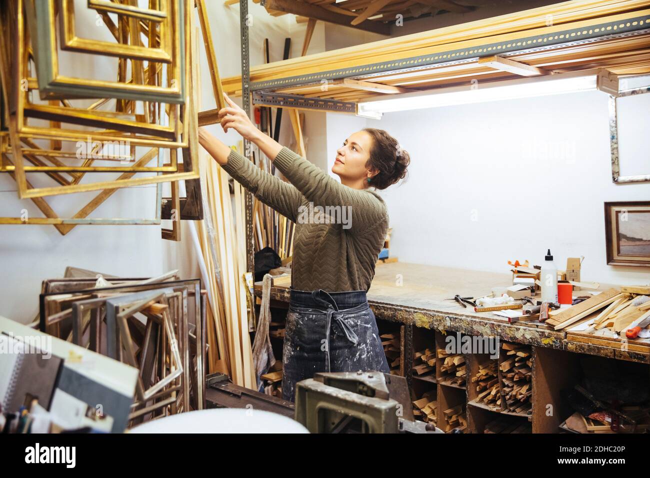 Jeune artiste confiante tenant un cadre à l'atelier Banque D'Images