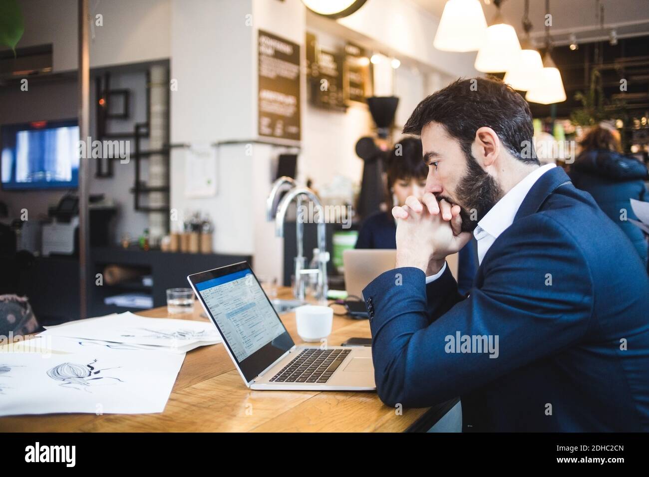 Vue latérale d'un homme confiant regardant un ordinateur portable table dans le bureau Banque D'Images