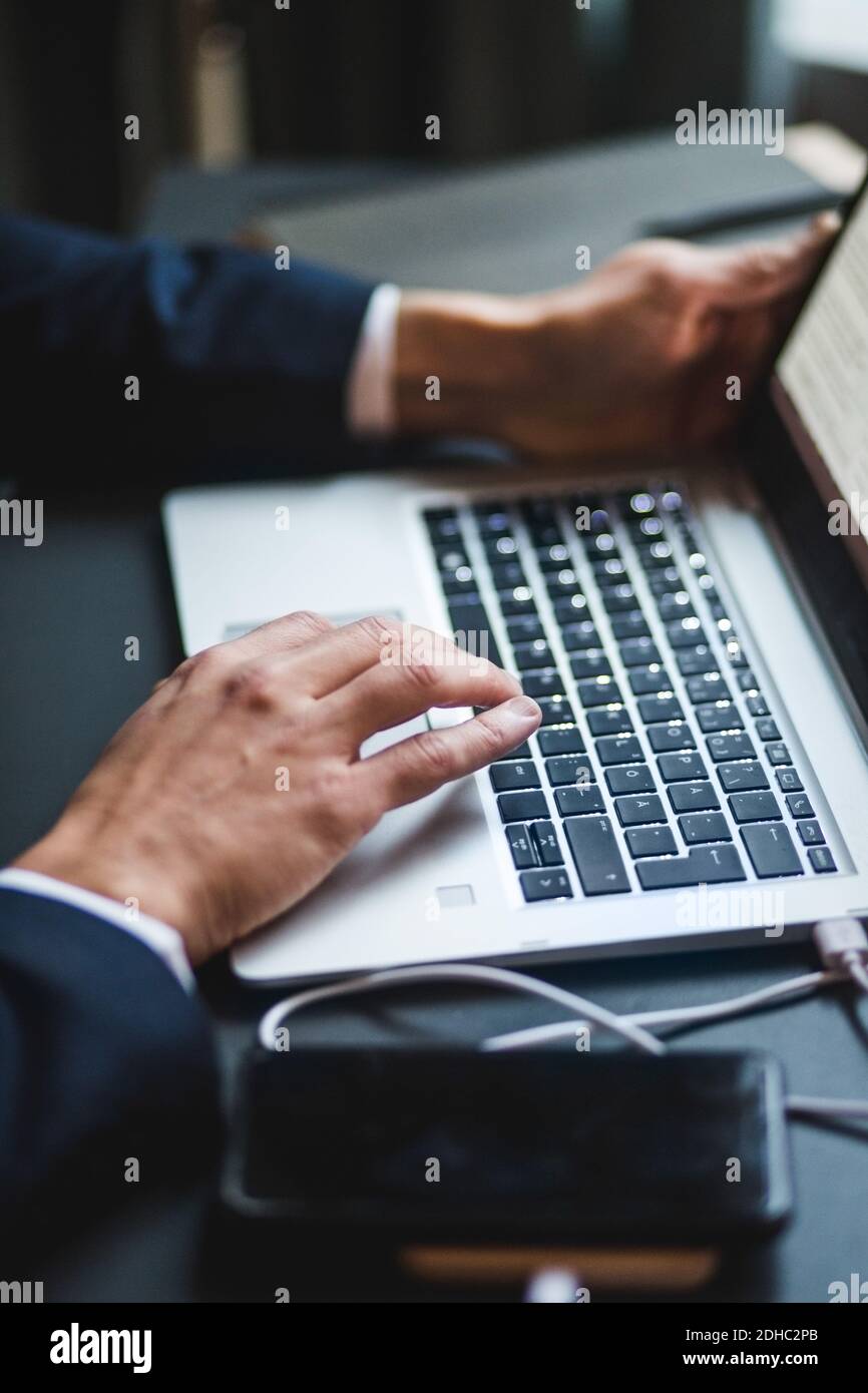 Les mains de l'homme d'affaires tapant sur le clavier de l'ordinateur portable au bureau bureau créatif Banque D'Images
