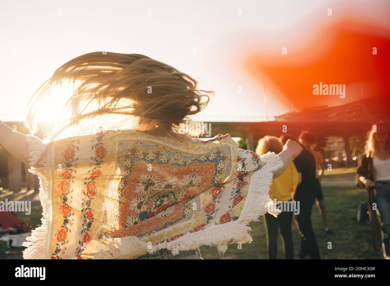 Vue arrière de la femme qui jette les cheveux tout en écoutant de la musique concert en été Banque D'Images