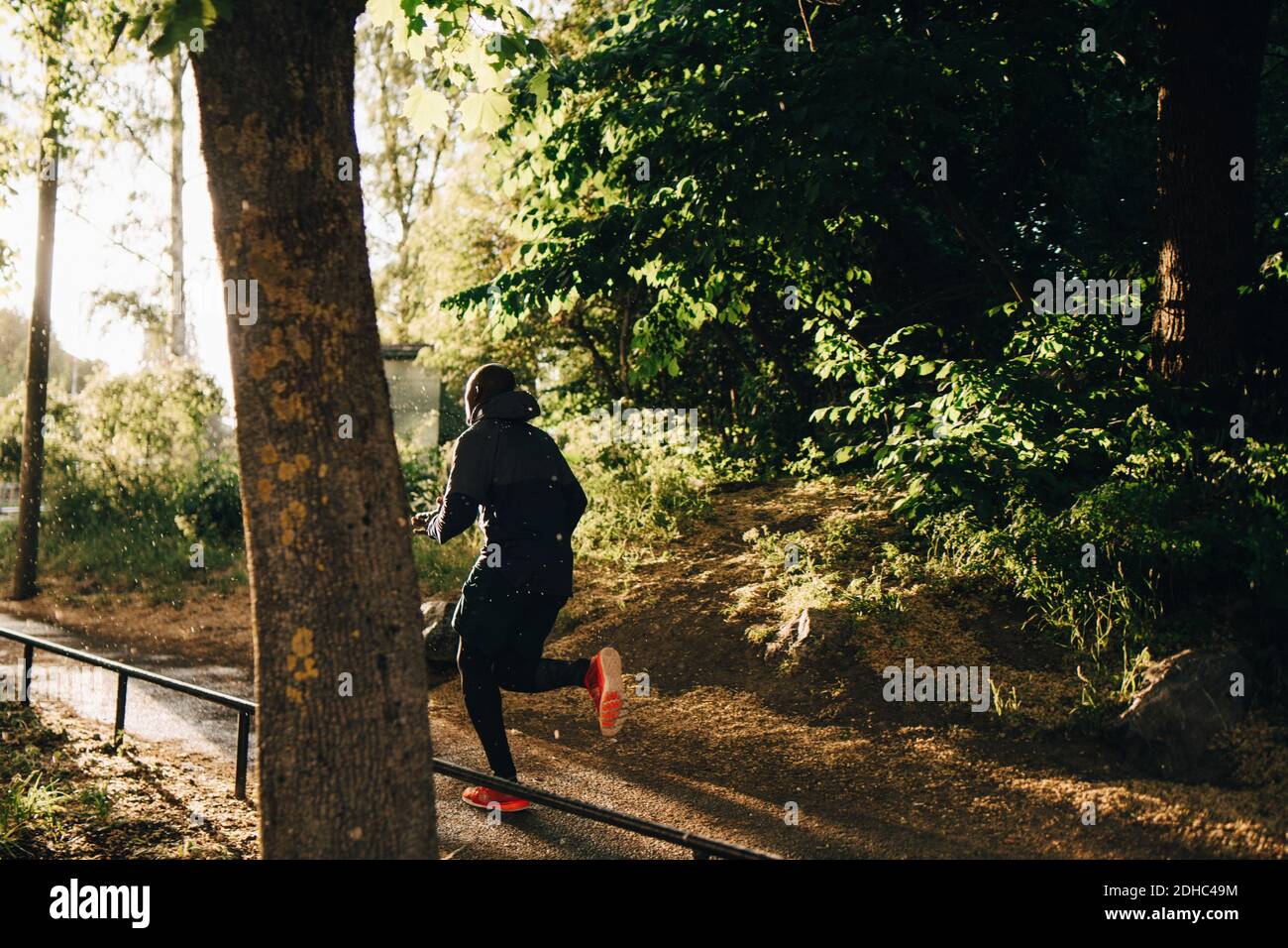 Pleine longueur d'athlète masculin qui court sur une piste de jogging dans le parc Banque D'Images