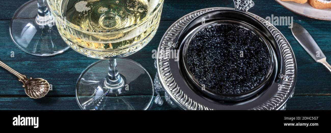 Panorama sur le champagne et le caviar. Coupe rétro en verre et bol Banque D'Images