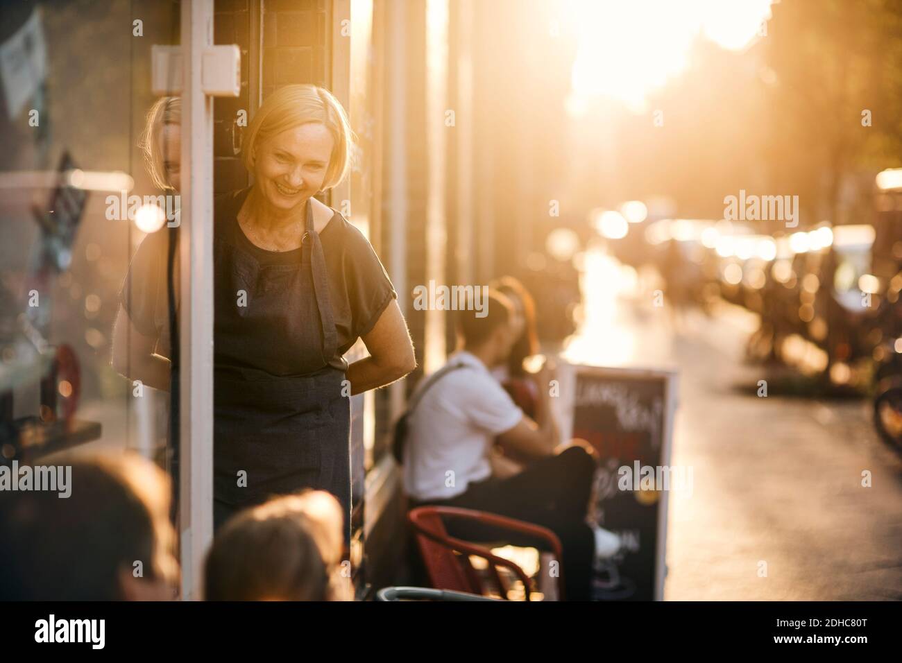 Portrait d'une employée souriante debout à l'entrée de l'épicerie fine Banque D'Images