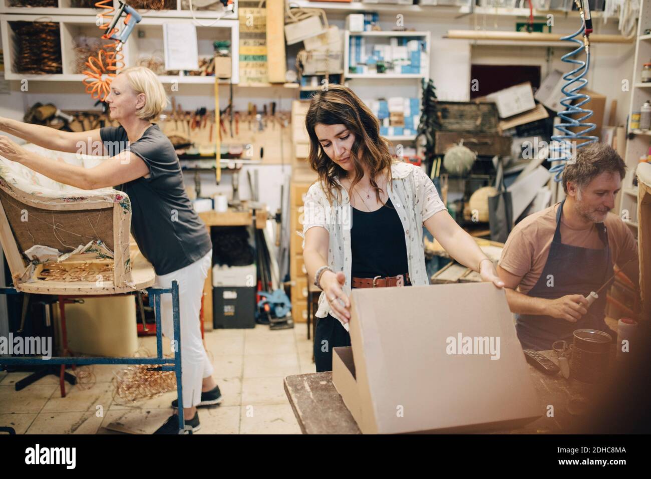 Hommes et femmes travaillant dans un atelier de sellerie Banque D'Images